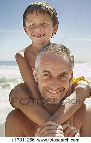 Father carrying son (5-6) on shoulders on beach portrait View Large Photo Image Stock Photograph - Father carrying son (5-6) on shoulders on beach portrait. Fotosearch