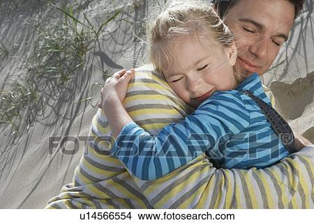 Father embracing daughter (5-6) on beach close-up View Large Photo Image Picture - Father embracing daughter (5-6) on beach close-up. Fotosearch