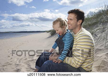 Father embracing daughter (5-6) sitting on beach View Large Photo Image Stock Photo - Father embracing daughter (5-6) sitting on beach. Fotosearch