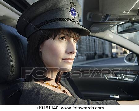 Stock Image - Female chauffeur in car on street. Fotosearch