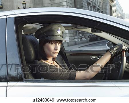 Stock Photo - Female chauffeur in car on street. Fotosearch
