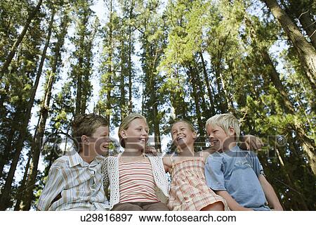 Four children (7-9) sitting in forest low angle view. View Large Photo Image Stock Photo - Four children (7-9) sitting in forest low angle view.. Fotosearch