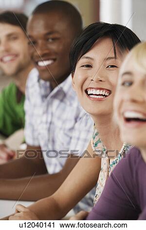 Stock Image - Four people in a row laughing.. Fotosearch