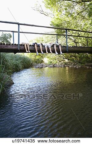 Four teenagers (16-17 years) lying on wooden bridge above river low section View Large Photo Image Stock Photography - Four teenagers (16-17 years) lying on wooden bridge above river low section. Fotosearch