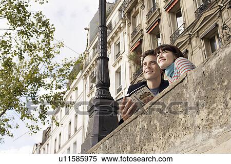 France Paris Couple looking over bridge with guidebook View Large Photo Image Stock Photography - France Paris Couple looking over bridge with guidebook. Fotosearch