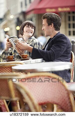 France Paris Couple reading guide book sitting outside cafe View Large Photo Image Stock Photo - France Paris Couple reading guide book sitting outside cafe. Fotosearch
