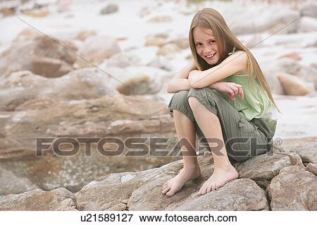 Girl (10-12) sitting on rock on beach portrait View Large Photo Image Stock Photo - Girl (10-12) sitting on rock on beach portrait. Fotosearch