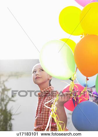 Stock Image - Girl (10-12) with bunch of balloons. Fotosearch