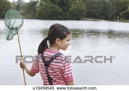 Girl (5-6) with fishing net by river View Large Photo Image Stock Photography - Girl (5-6) with fishing net by river. Fotosearch