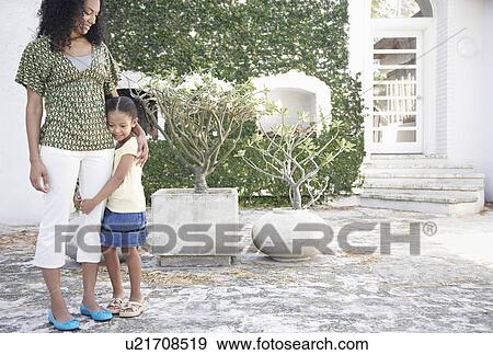 Girl (5-6 years) hugging mothers leg standing in yard View Large Photo Image Stock Photo - Girl (5-6 years) hugging mothers leg standing in yard. Fotosearch