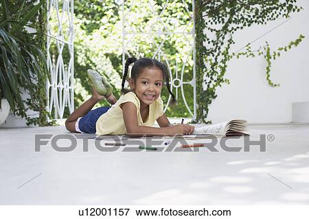Girl (5-6 years) lying on porch and drawing View Large Photo Image Stock Photo - Girl (5-6 years) lying on porch and drawing. Fotosearch