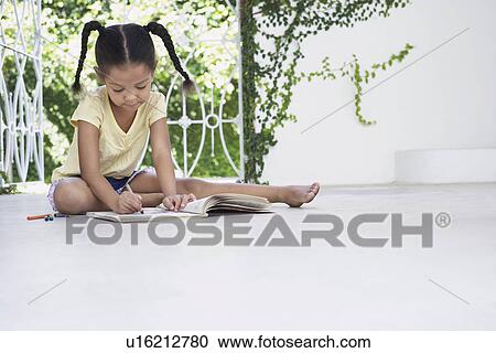 Stock Image - Girl (5-6 years) sitting on porch and drawing. Fotosearch