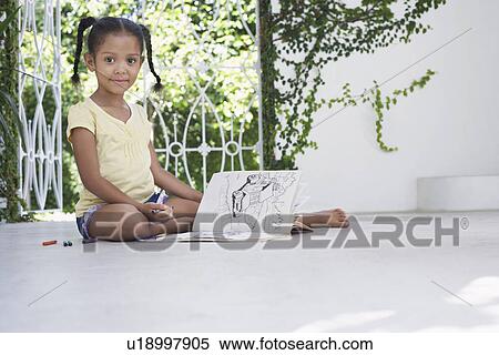 Stock Photography - Girl (5-6 years) sitting on porch and drawing. Fotosearch