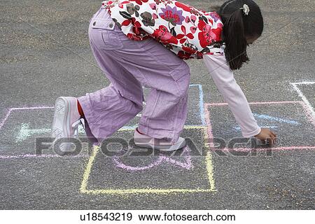 Stock Photo - Girl (7-9) playing hop-scotch in school playground. Fotosearch