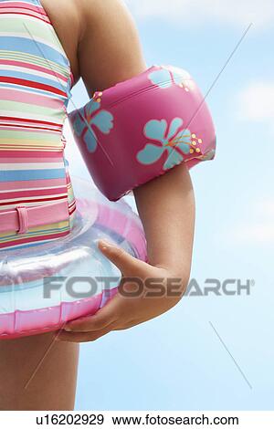 Girl (7-9 years) wearing inflatable ring and water wings mid section View Large Photo Image Stock Photo - Girl (7-9 years) wearing inflatable ring and water wings mid section. Fotosearch
