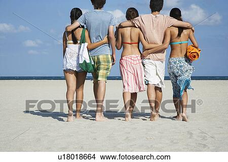 Group of teenagers (16-17) walking on beach back view View Large Photo Image Picture - Group of teenagers (16-17) walking on beach back view. Fotosearch