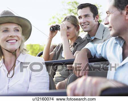 Group of tourists on safari sitting in jeep smiling View Large Photo Image Picture - Group of tourists on safari sitting in jeep smiling. Fotosearch