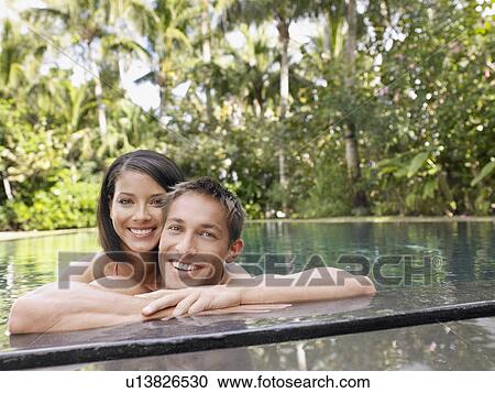 Stock Image - Happy Young Couple in Swimming Pool. Fotosearch