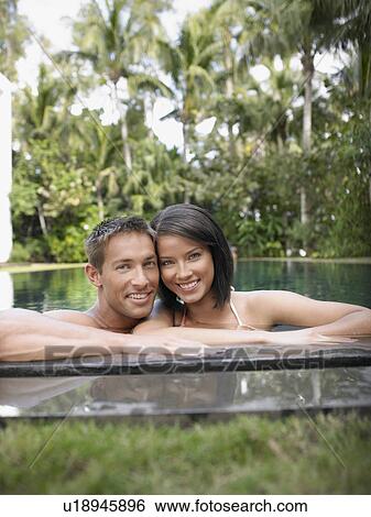 Stock Photograph - Happy Young Couple in Swimming Pool. Fotosearch