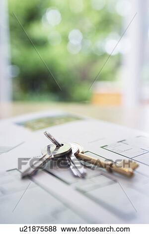 Stock Photo - Key ring with three keys lying on architectural blueprints close-up. Fotosearch