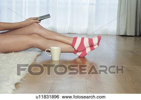 Low angle view of woman in stripey socks holding remote control View Large Photo Image Stock Photograph - Low angle view of woman in stripey socks holding remote control. Fotosearch