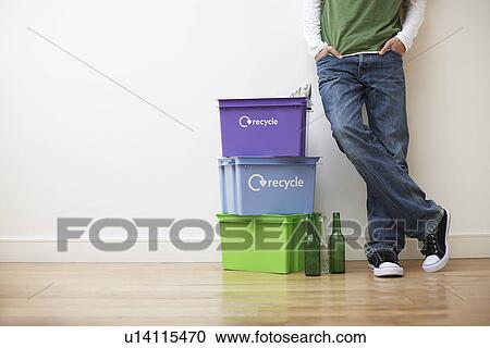 Low section view of young man leaning against wall next to small pile of recyling containers View Large Photo Image Stock Image - Low section view of young man leaning against wall next to small pile of recyling containers. Fotosearch