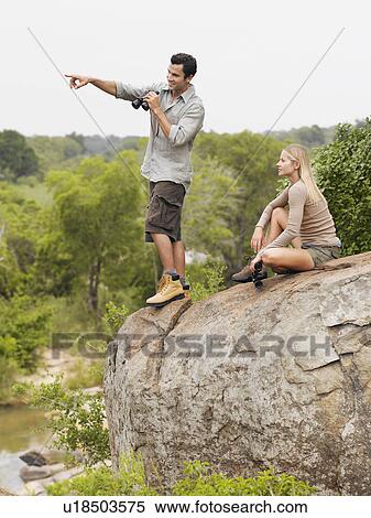 Man and woman on rock looking at view man pointing View Large Photo Image Stock Photography - Man and woman on rock looking at view man pointing. Fotosearch