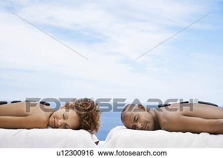 Man and woman receiving hot stone therapy at spa ocean behind View Large Photo Image Stock Photograph - Man and woman receiving hot stone therapy at spa ocean behind. Fotosearch