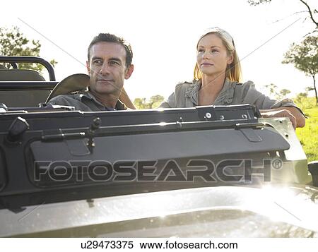 Man and woman sitting in jeep looking away View Large Photo Image Stock Photography - Man and woman sitting in jeep looking away. Fotosearch