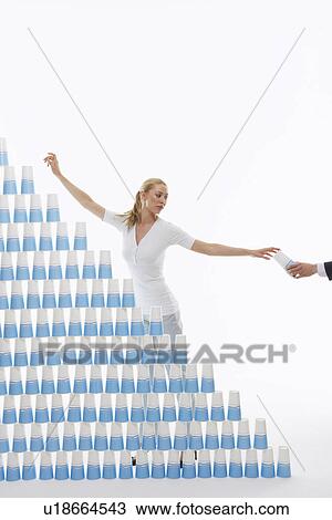 Man (close-up of hand) handing woman plastic cup for stacked pyramid against white background View Large Photo Image Stock Image - Man (close-up of hand) handing woman plastic cup for stacked pyramid against white background. Fotosearch