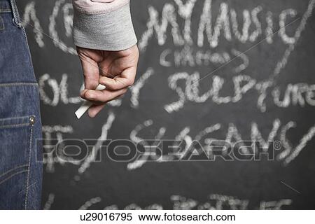 Man holding chalk standing in front of blackboard mid section close-up View Large Photo Image Stock Photography - Man holding chalk standing in front of blackboard mid section close-up. Fotosearch