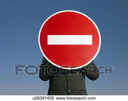 Man in suit holding 'no entry' sign in front of face half length View Large Photo Image Stock Photo - Man in suit holding 'no entry' sign in front of face half length. Fotosearch