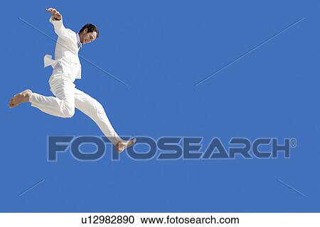 Man jumping mid air low angle view View Large Photo Image Stock Image - Man jumping mid air low angle view. Fotosearch