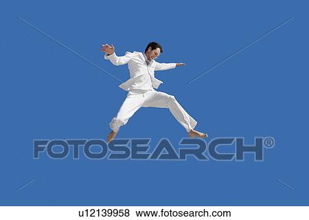 Stock Photo - Man jumping mid air low angle view. Fotosearch