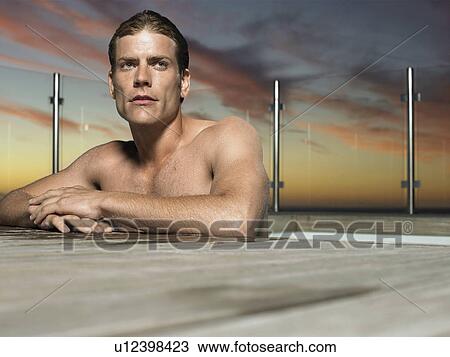 Man leaning on edge of outdoor pool at sunset View Large Photo Image Stock Image - Man leaning on edge of outdoor pool at sunset. Fotosearch