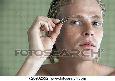 Stock Image - Man plucking eyebrows close-up. Fotosearch