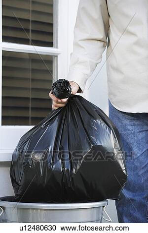 Man putting garbage bag into trash can mid section View Large Photo Image Stock Image - Man putting garbage bag into trash can mid section. Fotosearch