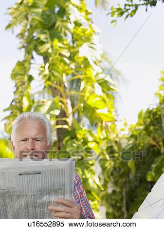 Man reading newspaper outdoors View Large Photo Image Stock Photography - Man reading newspaper outdoors. Fotosearch