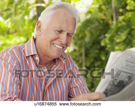 Stock Photography - Man reading newspaper outdoors. Fotosearch