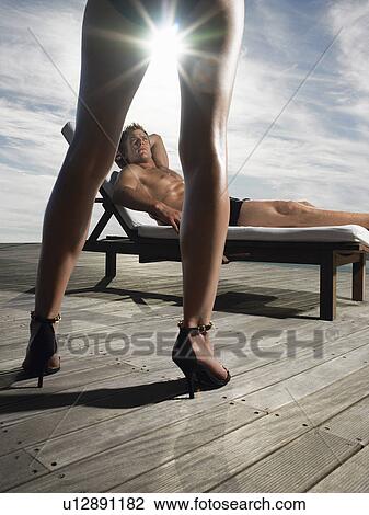 Man reclining on deck chair looking up at woman on deck View Large Photo Image Stock Image - Man reclining on deck chair looking up at woman on deck. Fotosearch