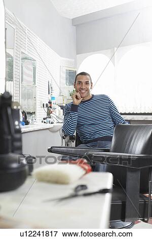 Man sitting in barbers shop smiling portrait View Large Photo Image Stock Photo - Man sitting in barbers shop smiling portrait. Fotosearch