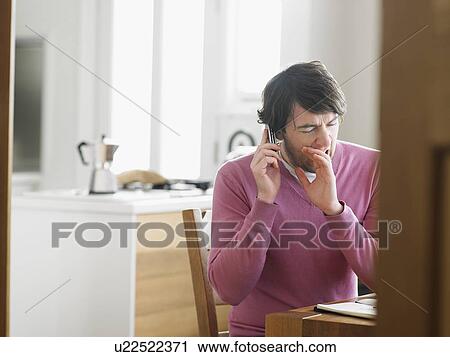 Man sitting in kitchen using phone View Large Photo Image Stock Image - Man sitting in kitchen using phone. Fotosearch