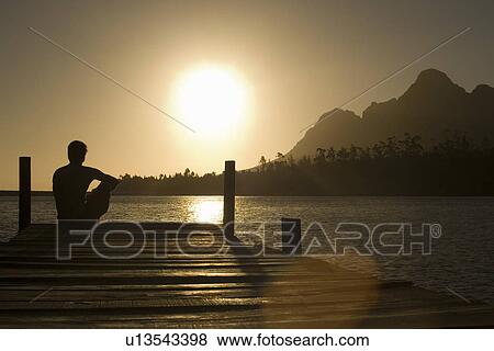 Man sitting on dock by lake back view. View Large Photo Image Stock Photo - Man sitting on dock by lake back view.. Fotosearch