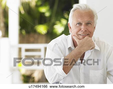 Stock Photograph - Man sitting on verandah portrait. Fotosearch