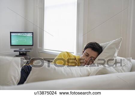 Picture - Man sleeping on sofa. Fotosearch