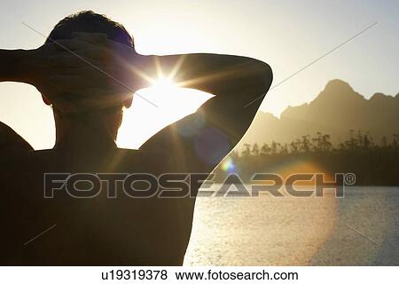 Man standing by lake with hands behind head back view. View Large Photo Image Stock Photo - Man standing by lake with hands behind head back view.. Fotosearch