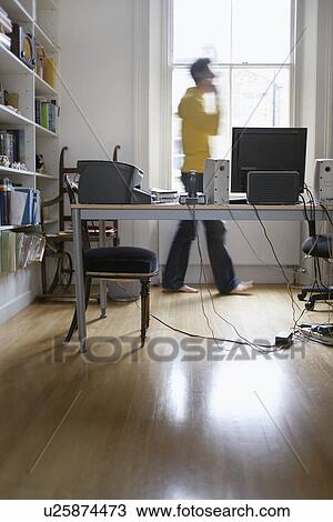 Stock Image - Man talking on phone at home motion blur. Fotosearch