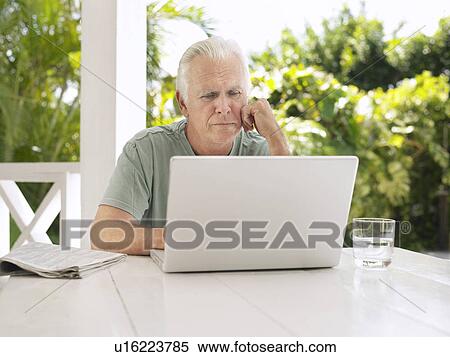 Man using laptop at verandah table View Large Photo Image Stock Photography - Man using laptop at verandah table. Fotosearch