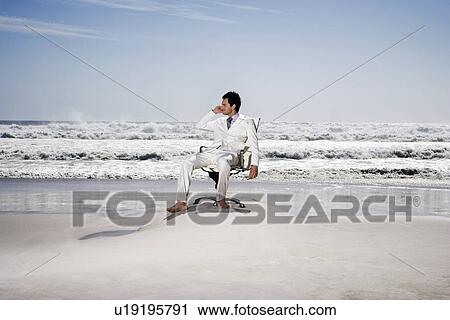 Man using mobile phone sitting on office chair on beach View Large Photo Image Stock Image - Man using mobile phone sitting on office chair on beach. Fotosearch