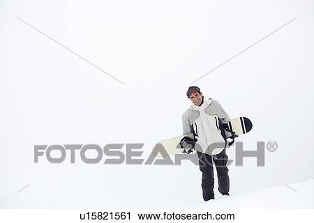 Man walking on snow carrying snowboard View Large Photo Image Stock Image - Man walking on snow carrying snowboard. Fotosearch